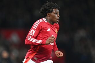 Patrick Dorgu runs in a Man United top