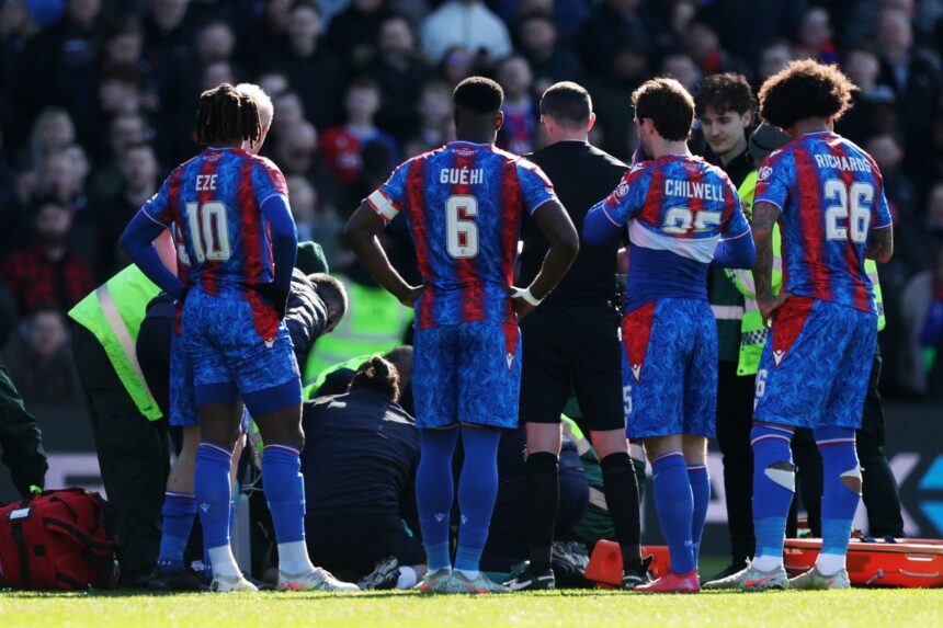 Jean-Philippe Mateta is attended to by paramedics while surrounded to by his team-mates