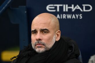 Pep Guardiola, Manager of Manchester City, looks on