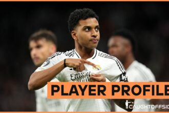 Rodrygo Goes celebrates by pointing to the Real Madrid badge on his shirt