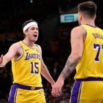 Austin Reaves #15 of the Los Angeles Lakers high fives teammate Luka Doncic #77 of the Los Angeles Lakers after a three point basket against the Denver Nuggets in the first half of a NBA basketball game at Crypto.com Arena.
