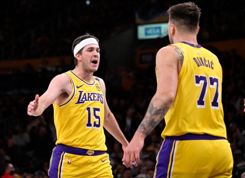 Austin Reaves #15 of the Los Angeles Lakers high fives teammate Luka Doncic #77 of the Los Angeles Lakers after a three point basket against the Denver Nuggets in the first half of a NBA basketball game at Crypto.com Arena.