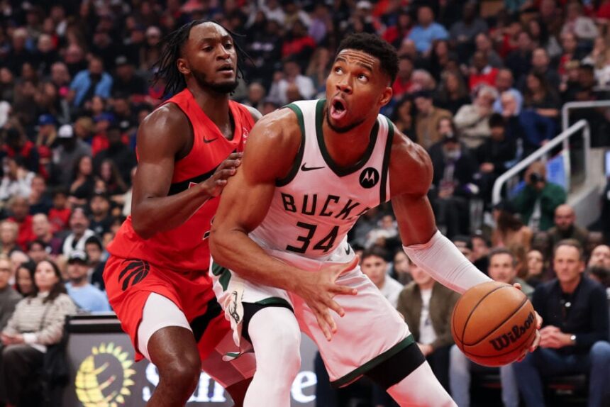 Giannis Antetokounmpo #34 of the Milwaukee Bucks controls the ball against Immanuel Quickley #5 of the Toronto Raptors during the first half at Scotiabank Arena.