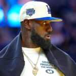 LeBron James courtside wearing white baseball cap