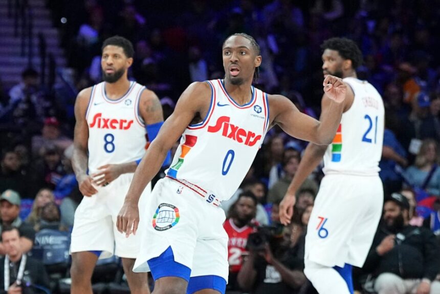 Tyrese Maxey #0, Paul George #8, and Joel Embiid #21 of the Philadelphia 76ers look on against the Toronto Raptors at the Wells Fargo Center.