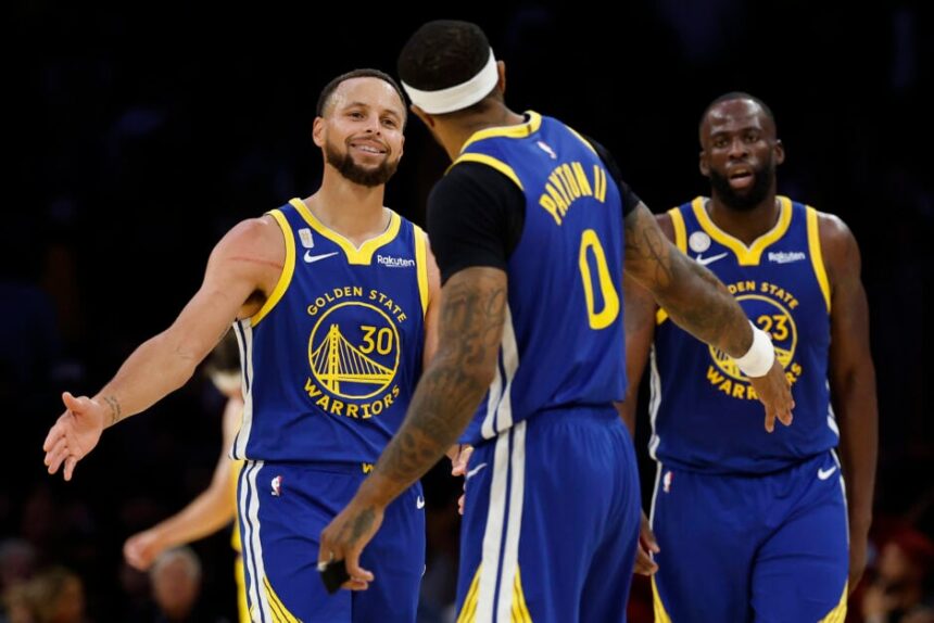 Stephen Curry #30 and Gary Payton II #0 of the Golden State Warriors celebrate in the final minute of the fourth quarter of the game against the Los Angeles Lakers at Crypto.com Arena.