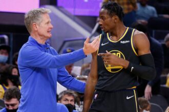 Golden State Warriors head coach Steve Kerr confers with forward Jonathan Kuminga during a game