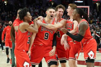 Nikola Vucevic #9 of the Chicago Bulls celebrates with teammates after making a buzzer-beating, three-point basket against the Portland Trail Blazers during the fourth quarter at the Moda Center.