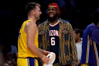 Los Angeles Lakers guard Luka Doncic (77) and forward LeBron James (23) interact during the first half of an NBA basketball game at Crypto.com Arena.