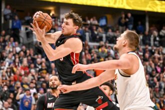 Nikola Jovic (5) of the Miami Heat grabs a rebound over similarly-named Nikola Jokic (15) of the Denver Nuggets during the second quarter at Ball Arena in Denver, Colorado on Wednesday, November 5, 2025.