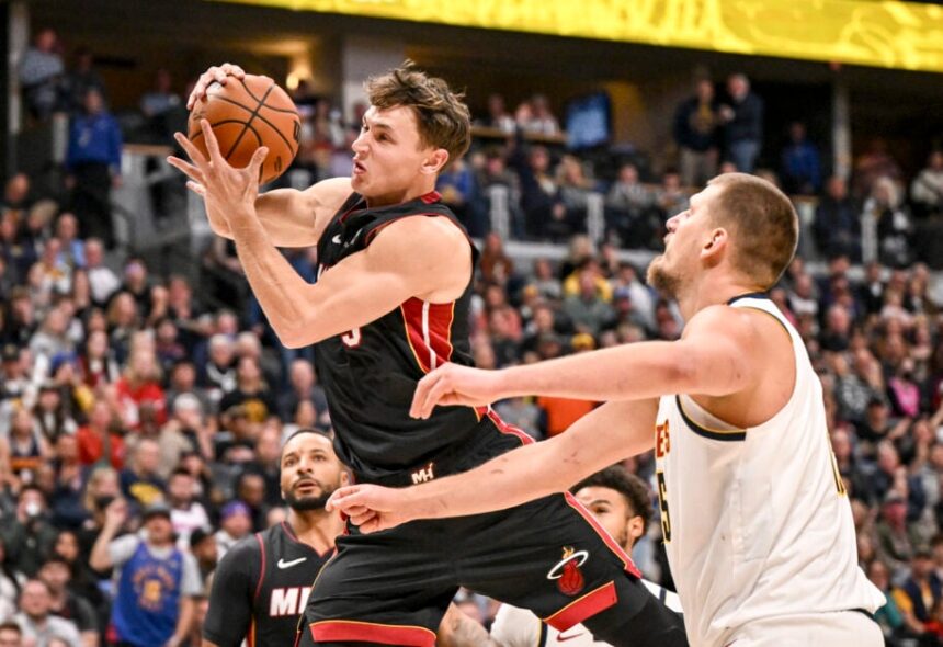 Nikola Jovic (5) of the Miami Heat grabs a rebound over similarly-named Nikola Jokic (15) of the Denver Nuggets during the second quarter at Ball Arena in Denver, Colorado on Wednesday, November 5, 2025.